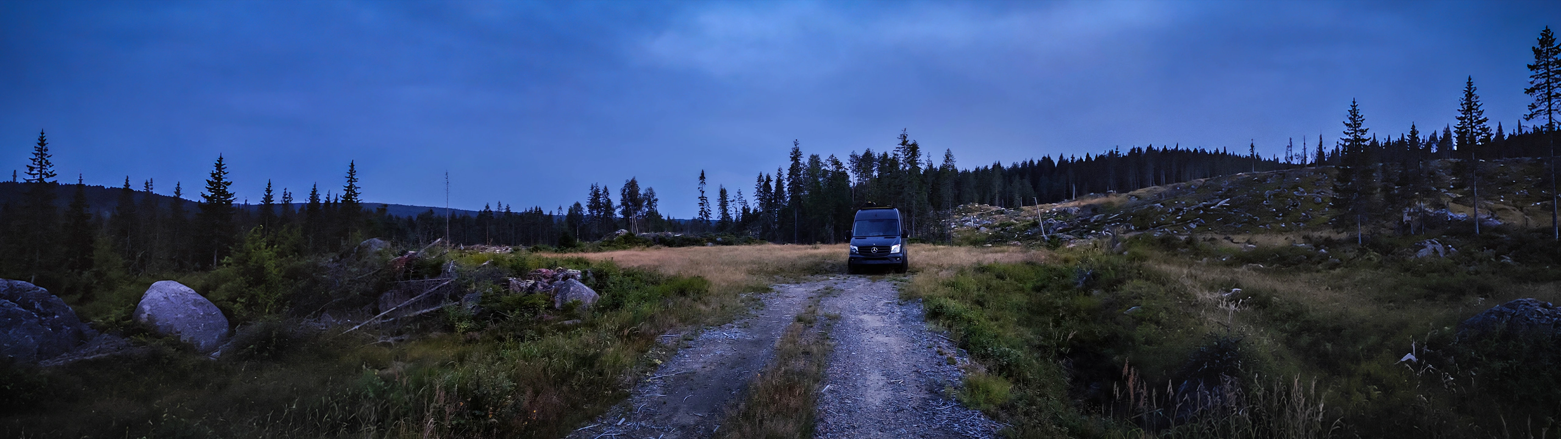 outarc Campervan in einer Waldlichtung zur blauen Stunde